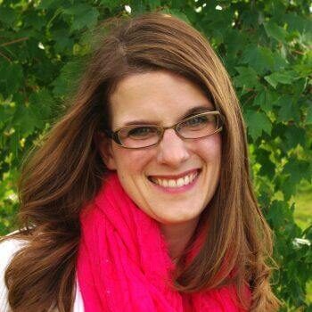 Headshot of Morgan Leu Parkhurst - pretty woman with glasses smiling with long brown hair and a pink scarf