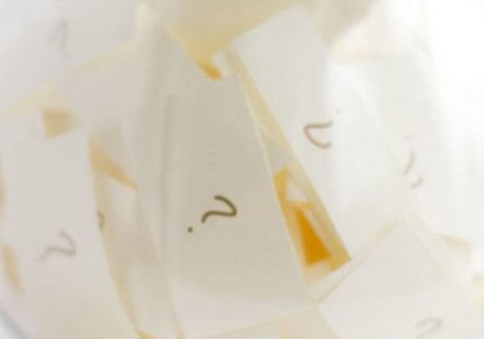 Clear glass jar with slips of paper with question marks written on them.