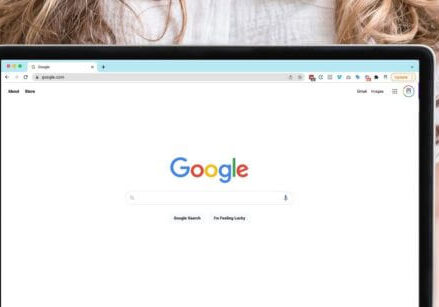 Woman holding a laptop that shows the Google search screen