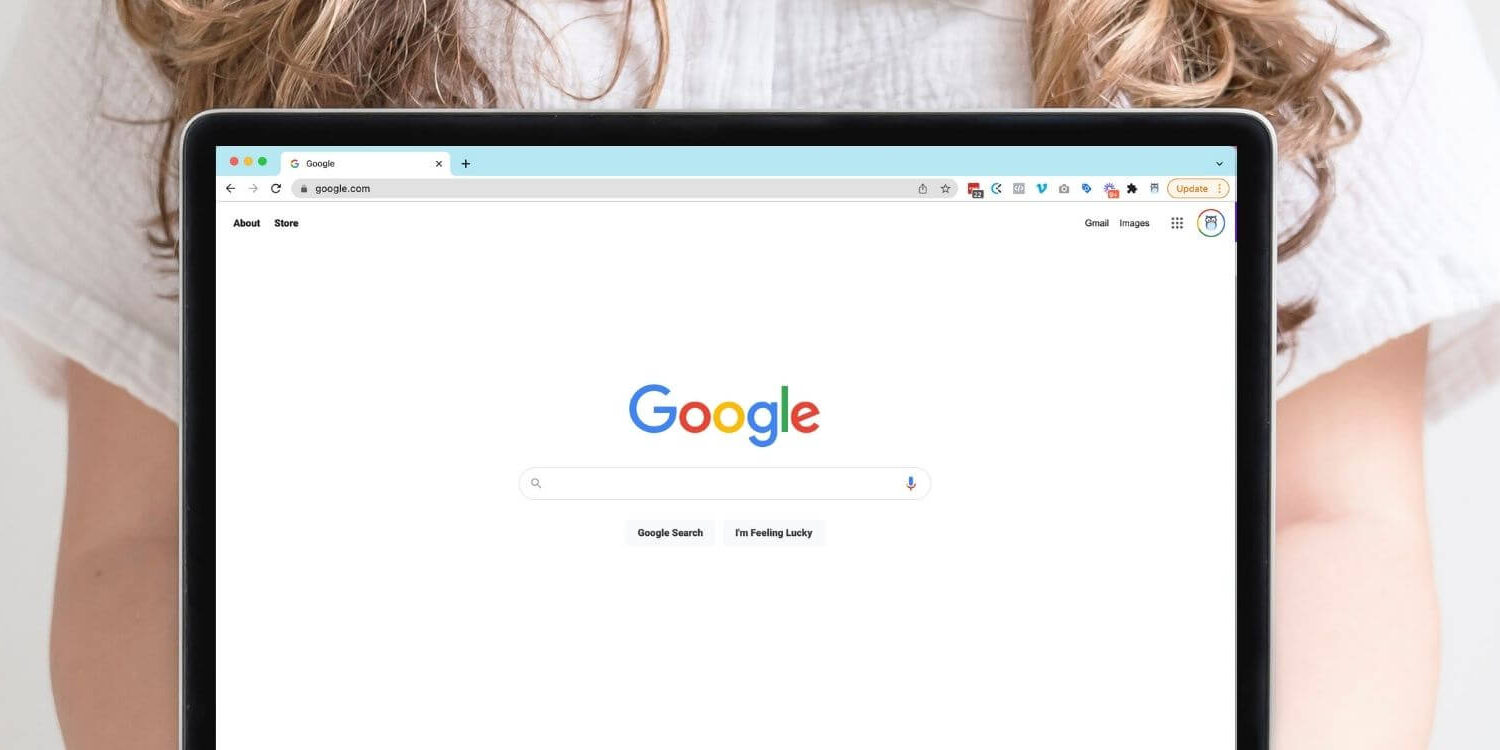 Woman holding a laptop that shows the Google search screen
