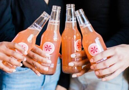 group of hands holding a soda bottle at a networking meeting or party