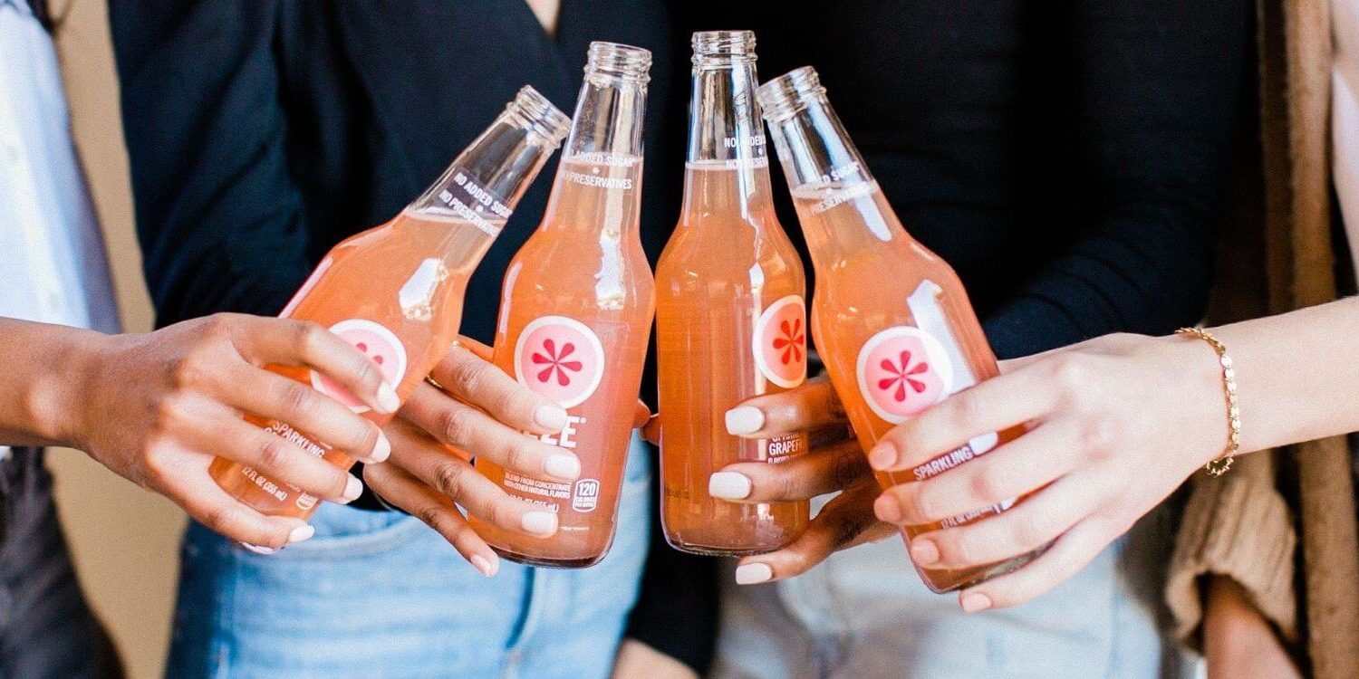 group of hands holding a soda bottle at a networking meeting or party