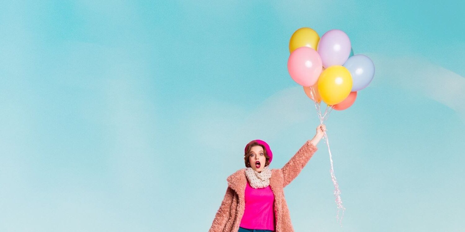 woman floating up in the sky holding on to a bundle of balloons