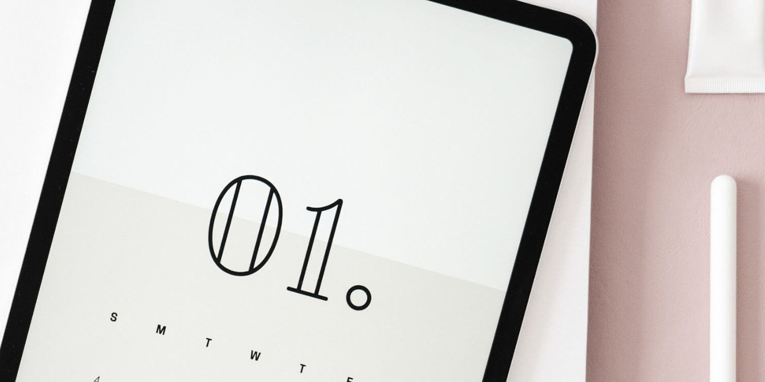 ipad with the number 01 on it laying on a blush pink desk with white desk accessories