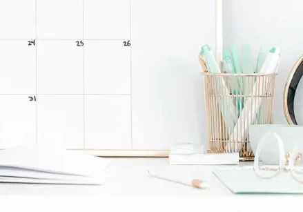 desk with a calendar, clock, and mint-green accessories