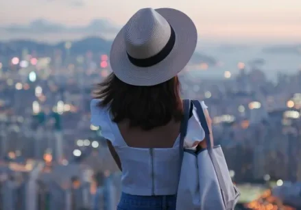 woman looking at the skyline of a city that looks hazy in the background
