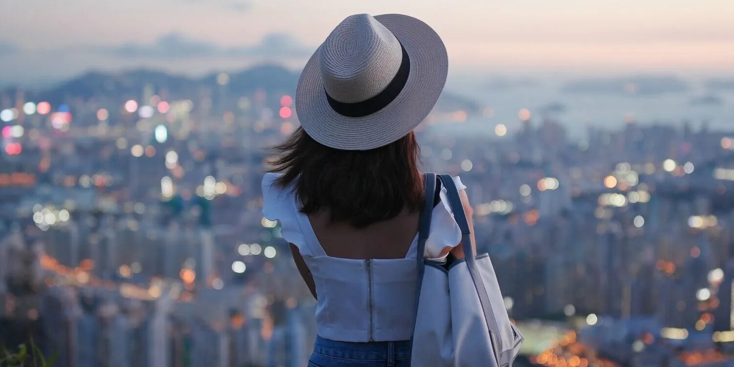 woman looking at the skyline of a city that looks hazy in the background