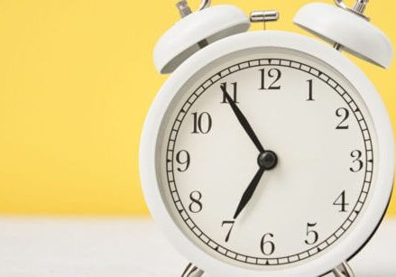 white alarm clock on a yellow background timesaving wordpress tip