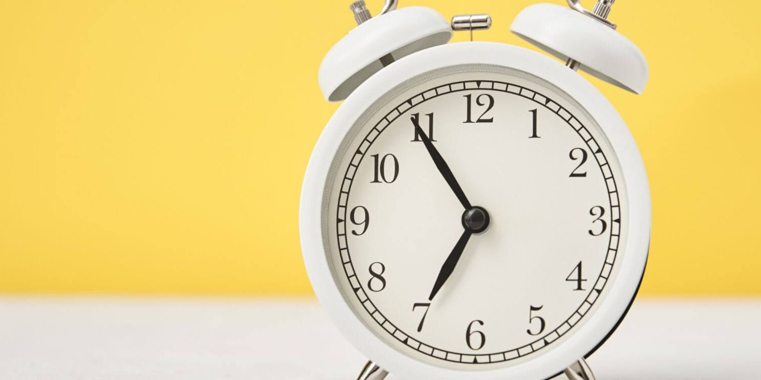 white alarm clock on a yellow background timesaving wordpress tip