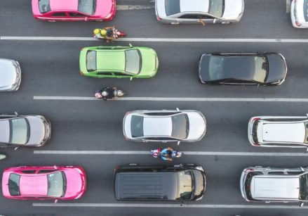 an overhead view of a four-lane road showing colorful cars in bumper to bumper traffic