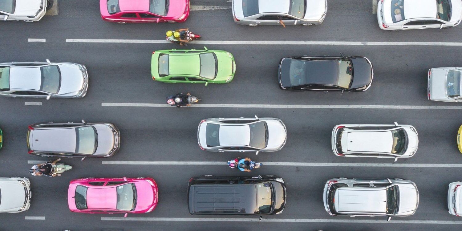 an overhead view of a four-lane road showing colorful cars in bumper to bumper traffic