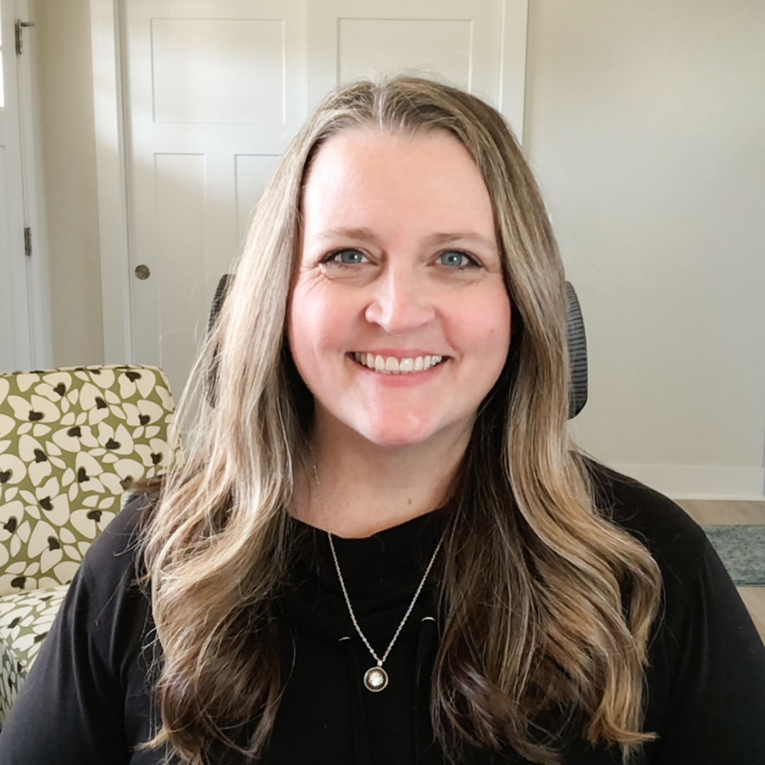 Cropped version of heather stephens woman with long brown hair sitting in her home office