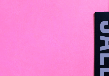 Black Friday sale tag hanging against a hot pink background.