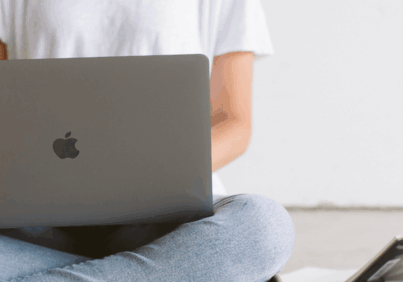 A business owner working on her laptop and maintaining consistency in marketing