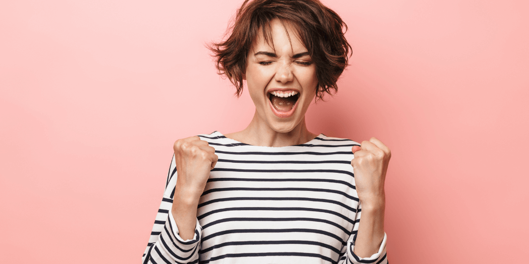 Woman doing an excited fist bump to crush content marketing overwhelm