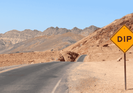 road in the desert with a street sign that says DIP don't quit