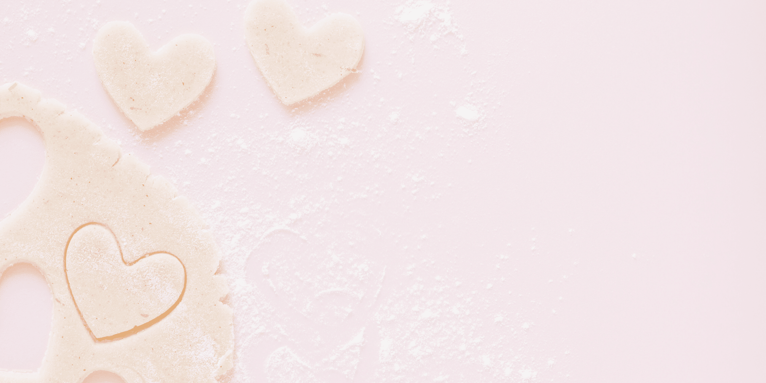 heart shaped sugar cookie dow cut outs on a pink table.